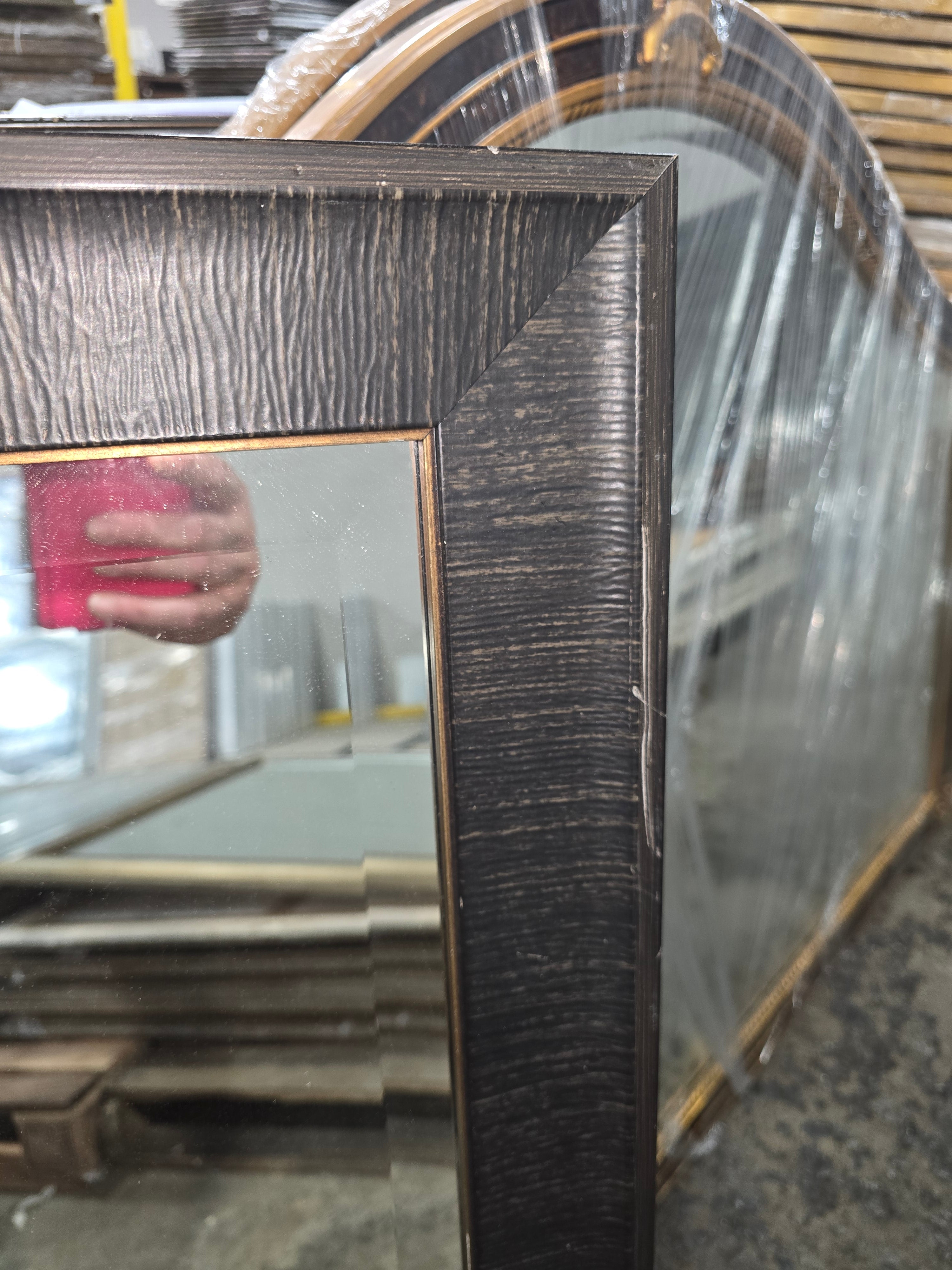 Close up of textured dark brown mirror frame with bronze inner trim on 24 x 36 wall mirror