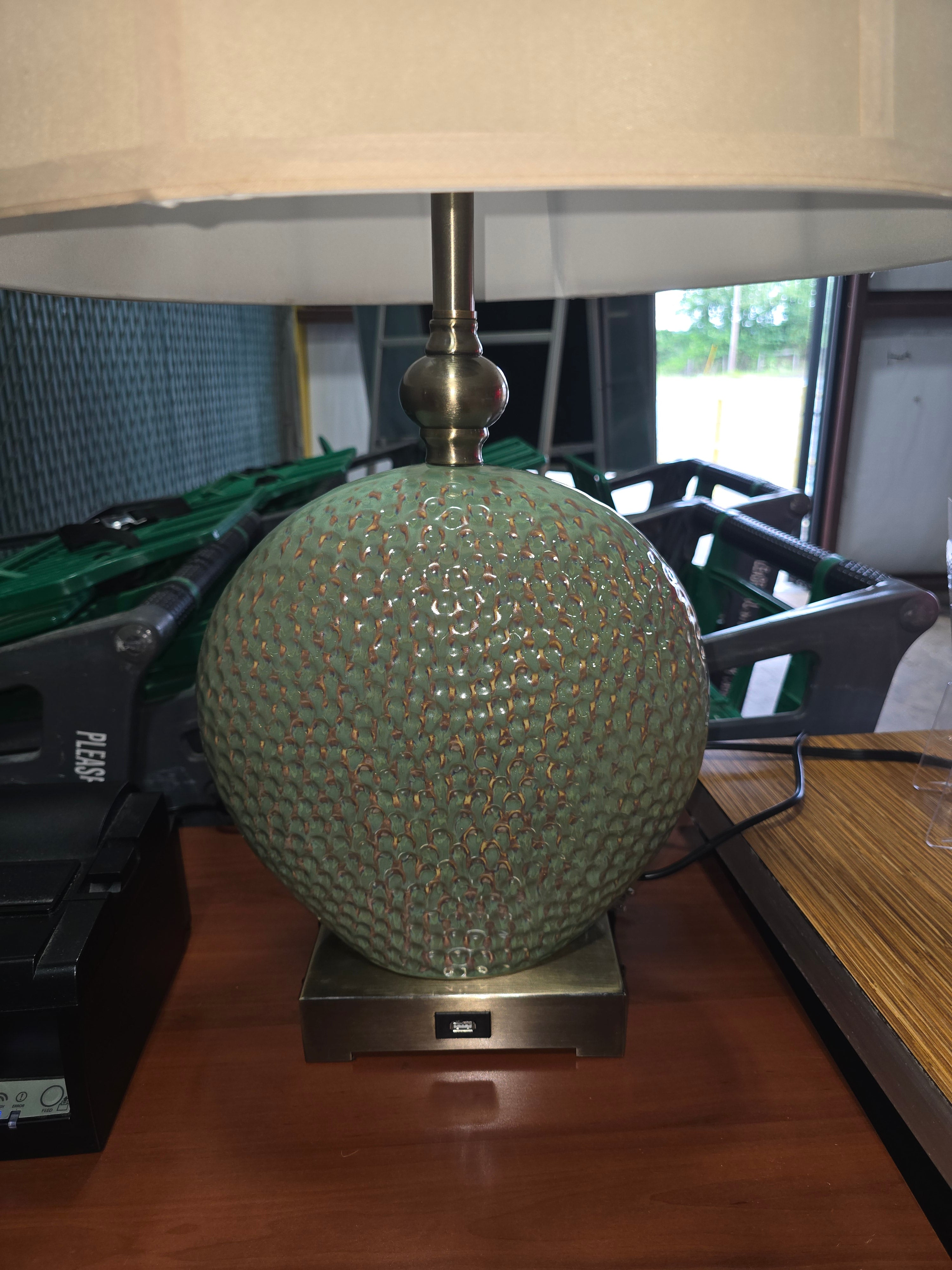 SHL close-up of textured seafoam ceramic table lamp base with built-in USB charging port and standard power outlet sourced from an upscale resort