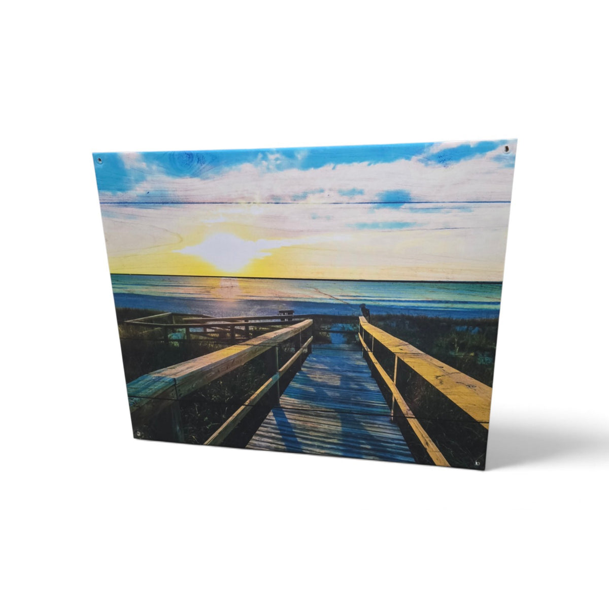 Large coastal wall art showing a wooden boardwalk leading to ocean at sunset in blue and gold tones