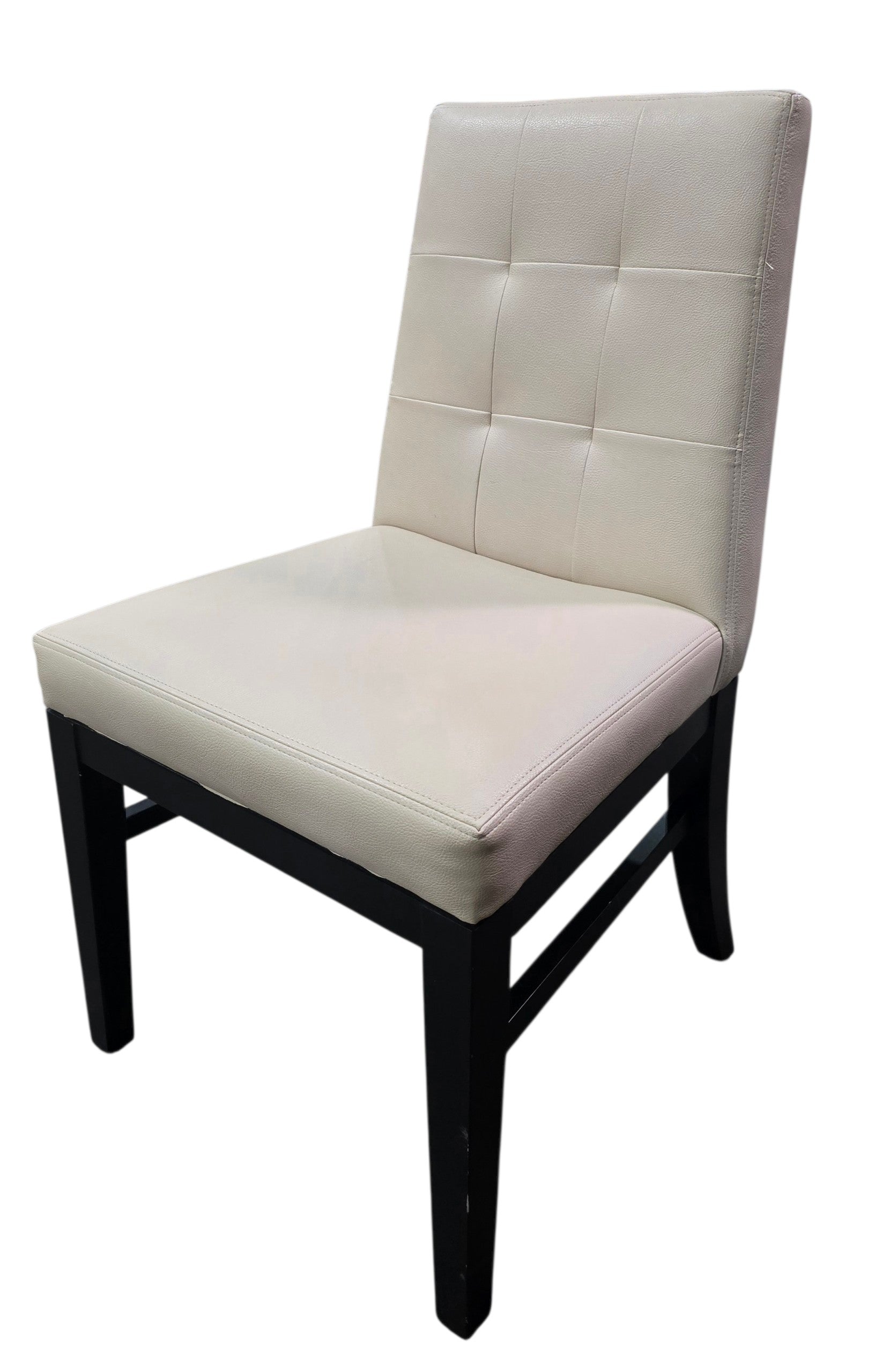 Angled view of used commercial cream vinyl dining chair with black wood frame, quality used resort furniture from SHL.
