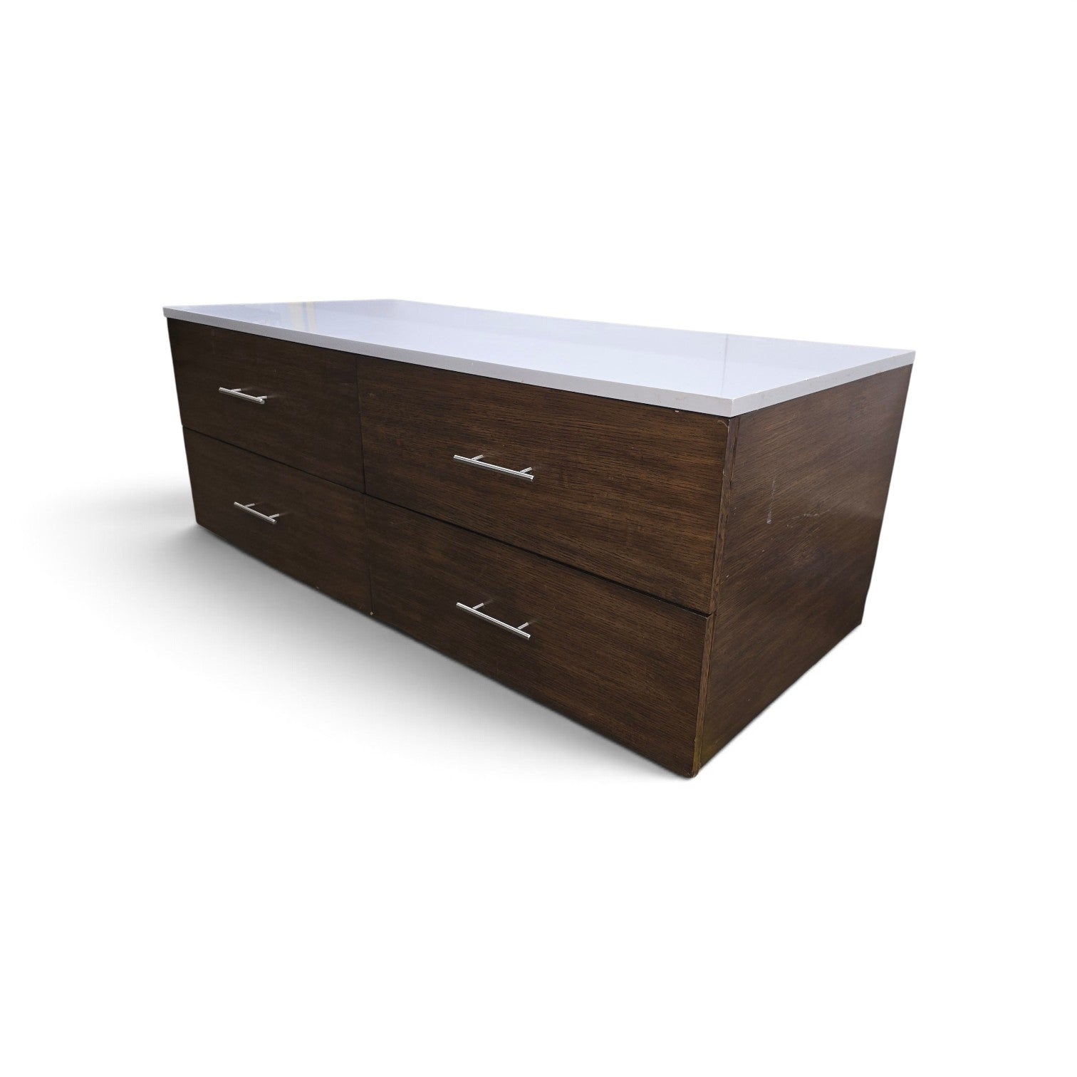Angled view of a used modern dark wood 4 drawer dresser with white granite top from Southern Hospitality Liquidation