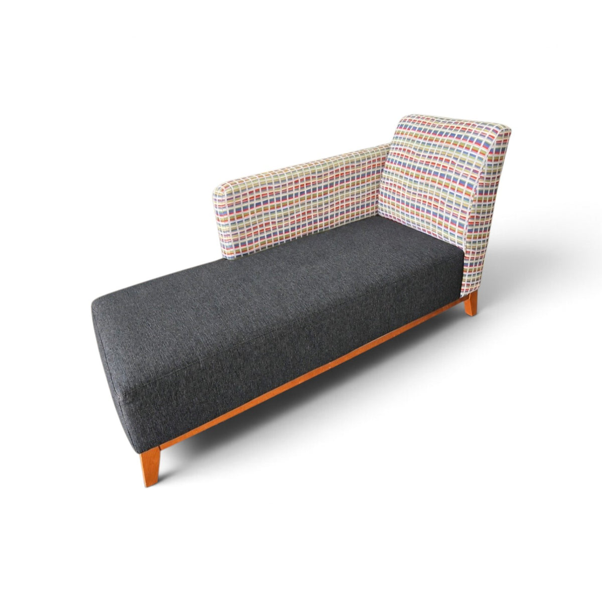 Used modern upholstered chaise lounge with charcoal gray seat, colorful geometric patterned back and wood-finish legs, SHL
