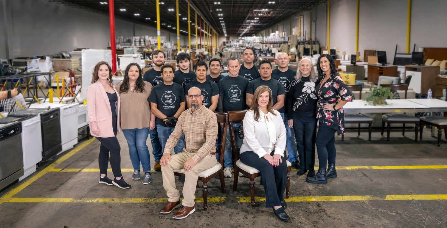 Southern Hospitality Liquidation family team smiling together inside the Cartersville GA warehouse, showcasing their small business values.
