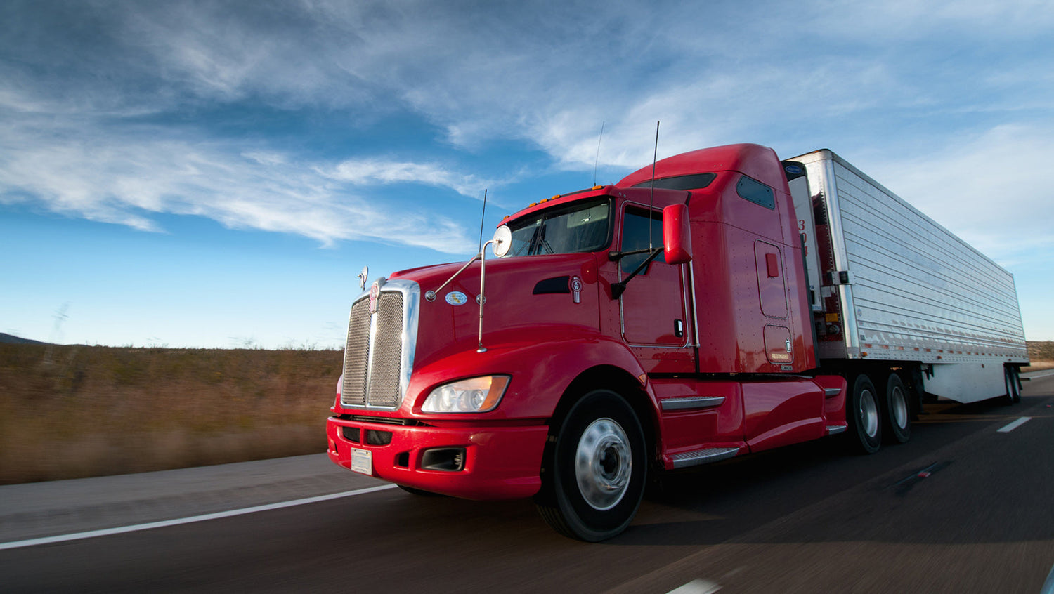 Truck on highway representing SHL drivers spending long hours delivering hotel furniture nationwide