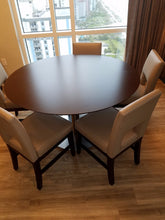 Round hotel dining table with chairs staged in Hilton Grand Vacations dining area – liquidation furniture