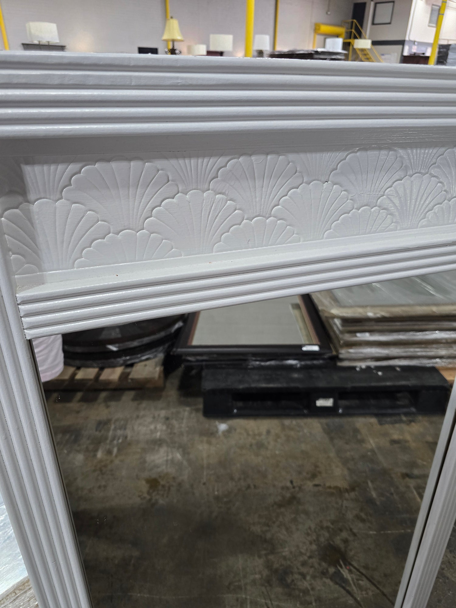 Close-up detail of white shell motif mirror frame with decorative coastal-inspired design