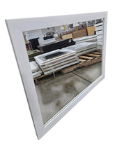 Angled view of contemporary white framed rectangular wall mirror measuring 44 x 33 inches