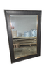 Dark brown framed wall mirror measuring 24 x 36 with bronze inner trim