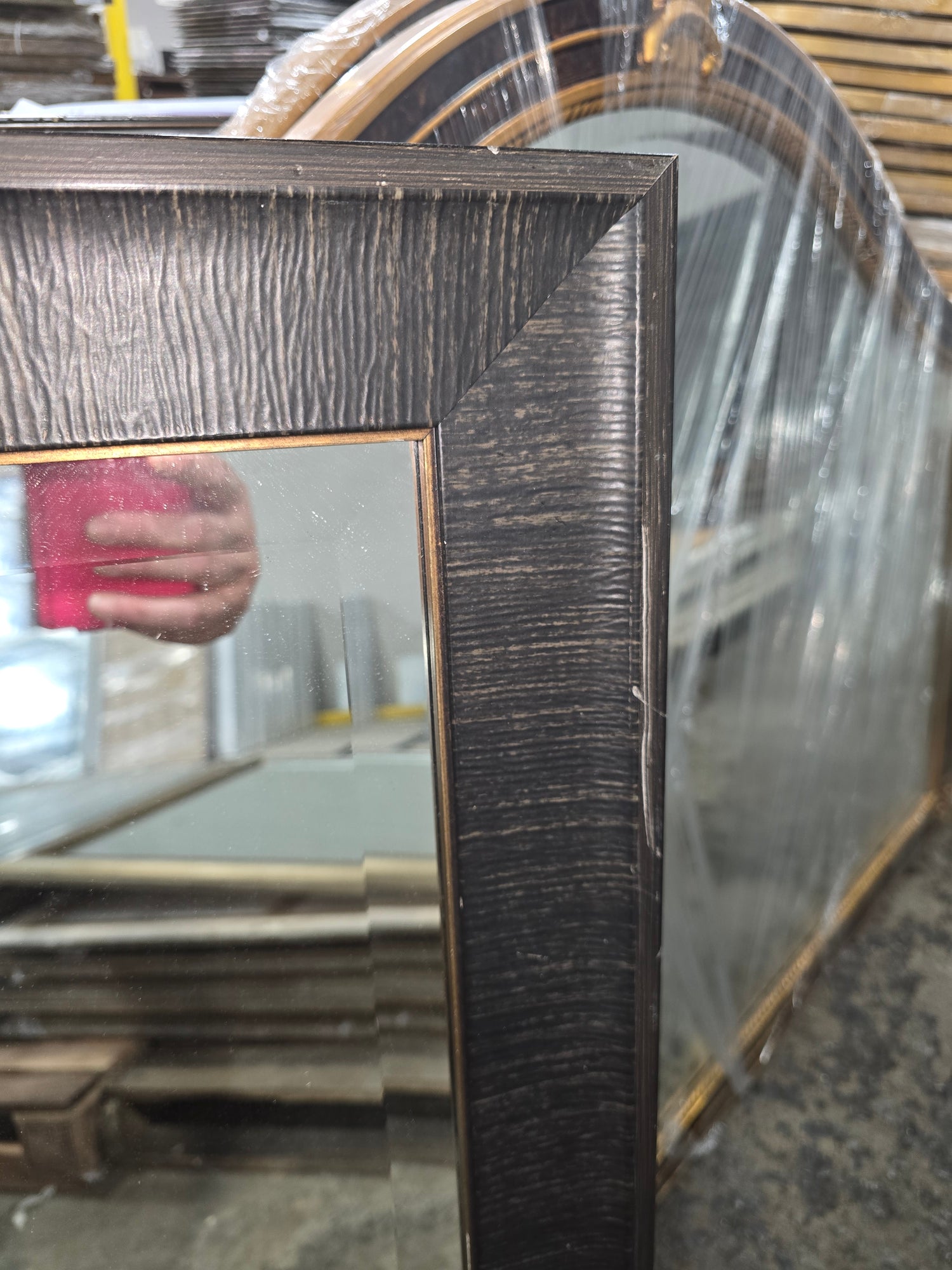 Close up of textured dark brown mirror frame with bronze inner trim on 24 x 36 wall mirror