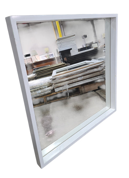 Angled view of modern white framed square wall mirror measuring 28 x 28 x 2 inches