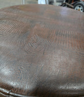 Close-up of vinyl upholstery detail on round ottoman