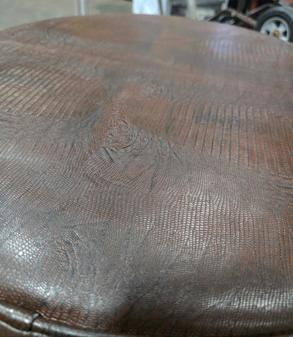 Close-up of vinyl upholstery detail on round ottoman