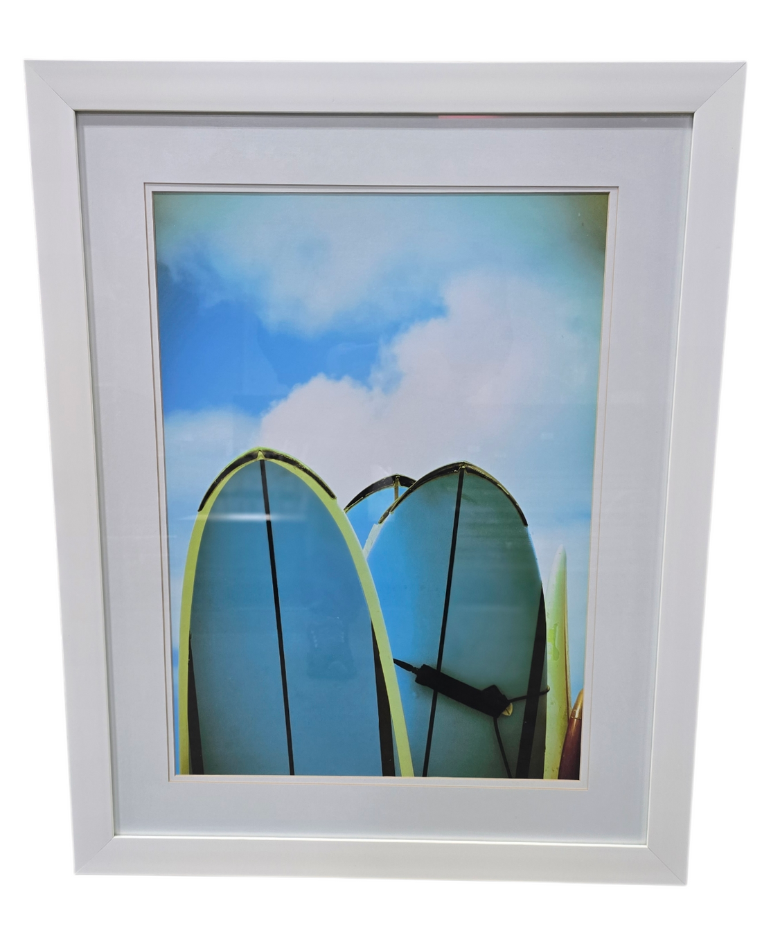Coastal wall art featuring the tops of three surfboards in the sand with blue sky and clouds