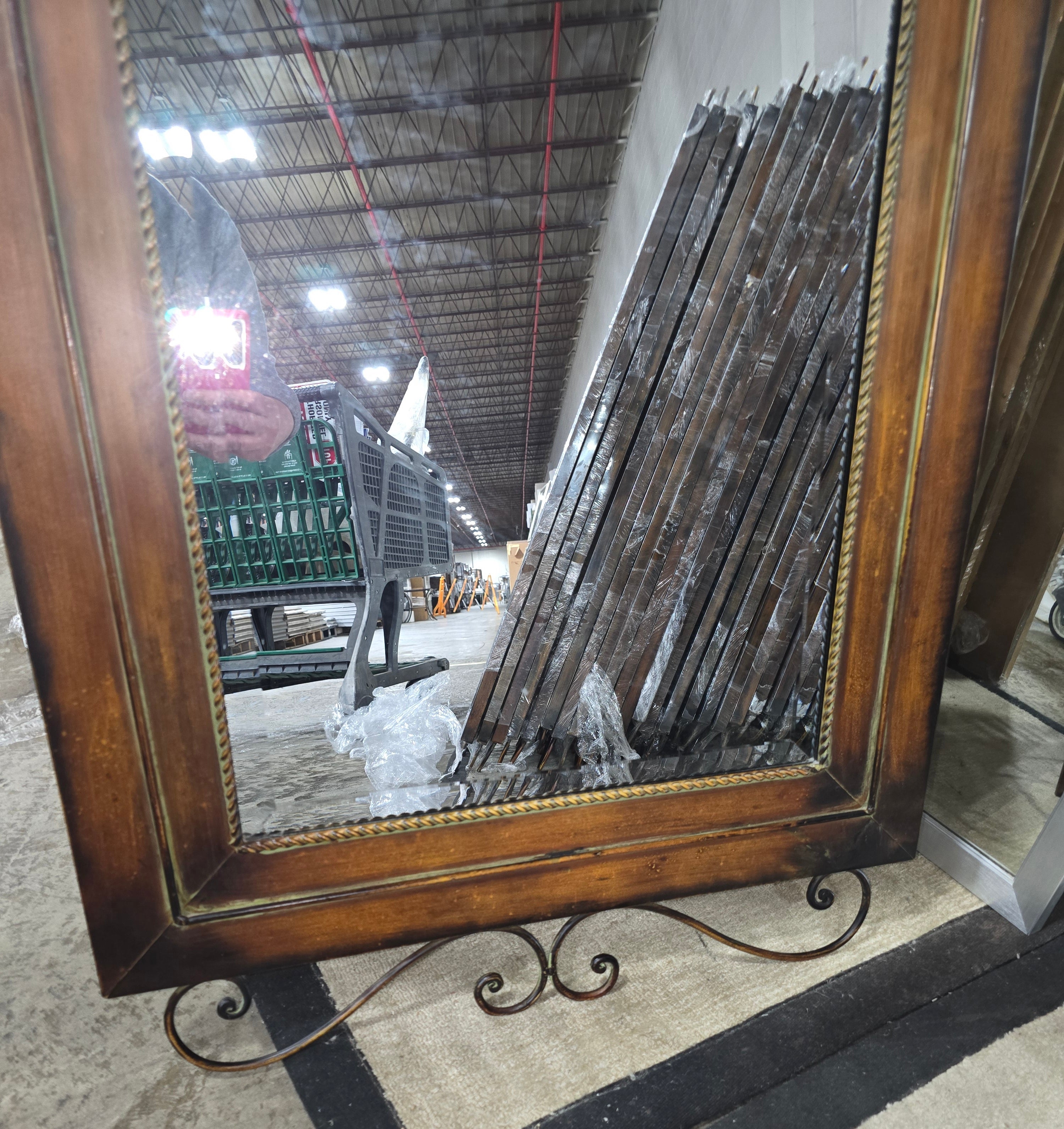 Angled view of full length mirror with decorative metal border