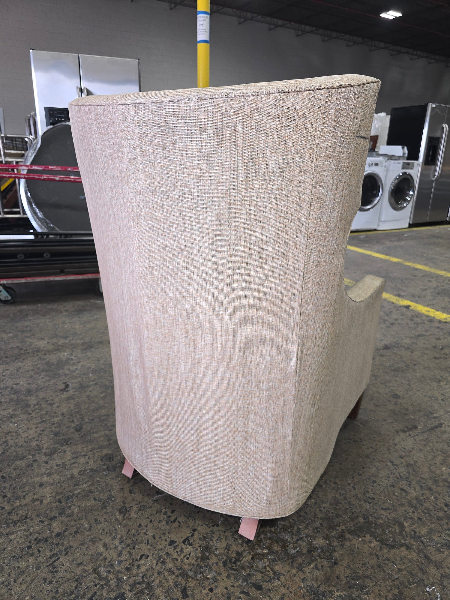 SHL used neutral beige wingback accent chair rear view displaying textured upholstery and tapered wood legs