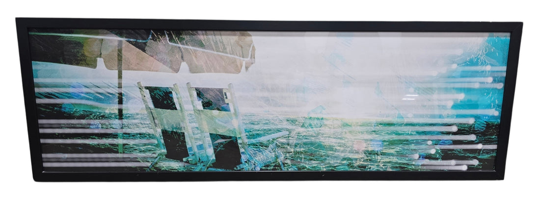 SHL panoramic coastal beach wall art featuring ocean waves beach chairs and turquoise abstract accents with black frame measuring 72 x 24 used in good condition
