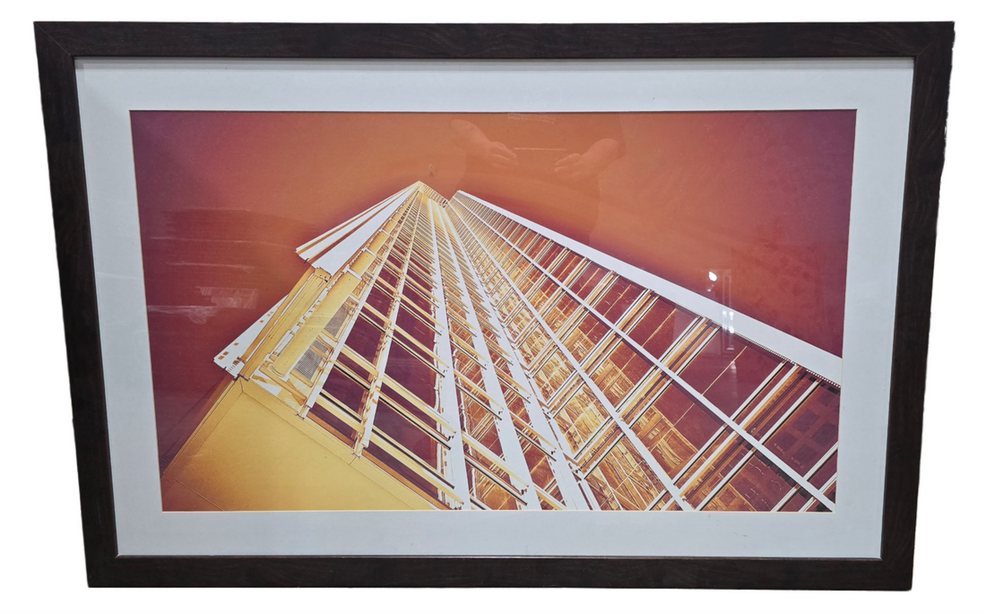 53.5 x 35.5 framed wall art of orange-lit skyscrapers in Midtown Atlanta, ground view looking upward, available at Southern Hospitality Liquidation in Cartersville GA