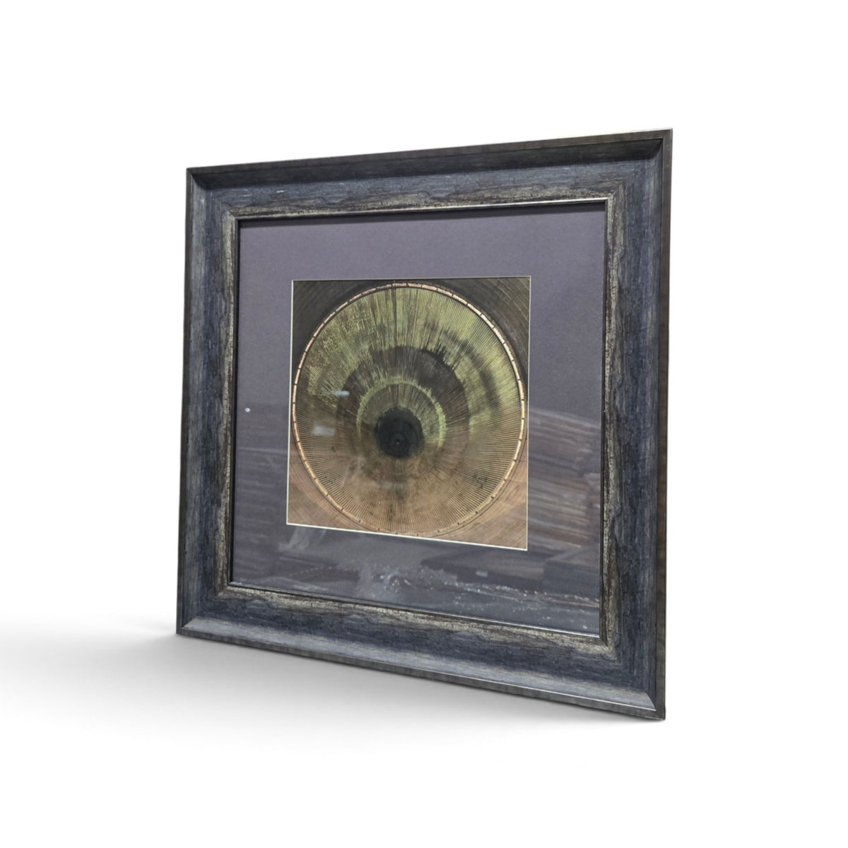 Framed abstract artwork with olive green circular woodgrain design and dark rustic frame