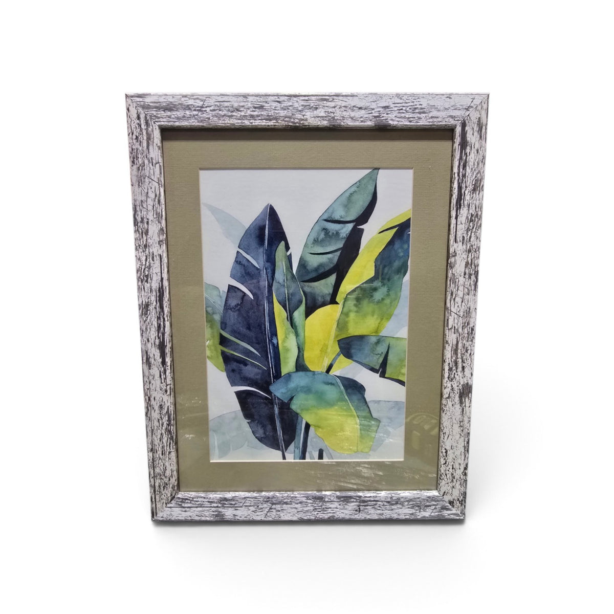 Framed tropical botanical artwork with blue green and yellow leaves and distressed whitewashed frame