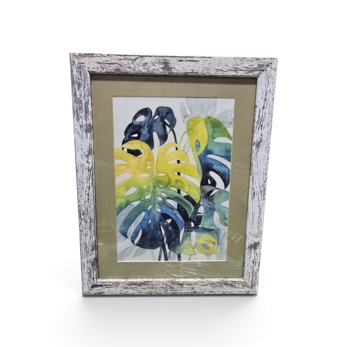 Framed tropical monstera leaf artwork in blue green and yellow with distressed whitewashed frame