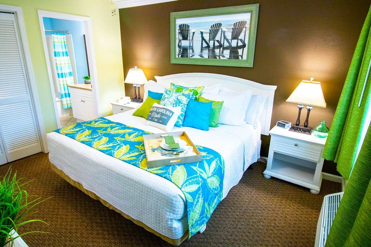 Used Grand Palms king room furniture package – mattress, headboard, TV dresser, nightstands, lamps, accent chair, and art