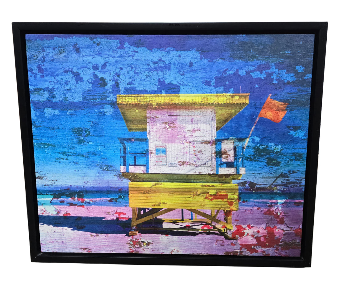 “Lifeguard on Duty” canvas wall art, 24 x 20 inches, with black frame. Scenic coastal artwork for homes, rentals, or hotel spaces.