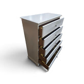 Used white five-drawer chest with decorative wave-pattern fronts and open drawers, SHL.
