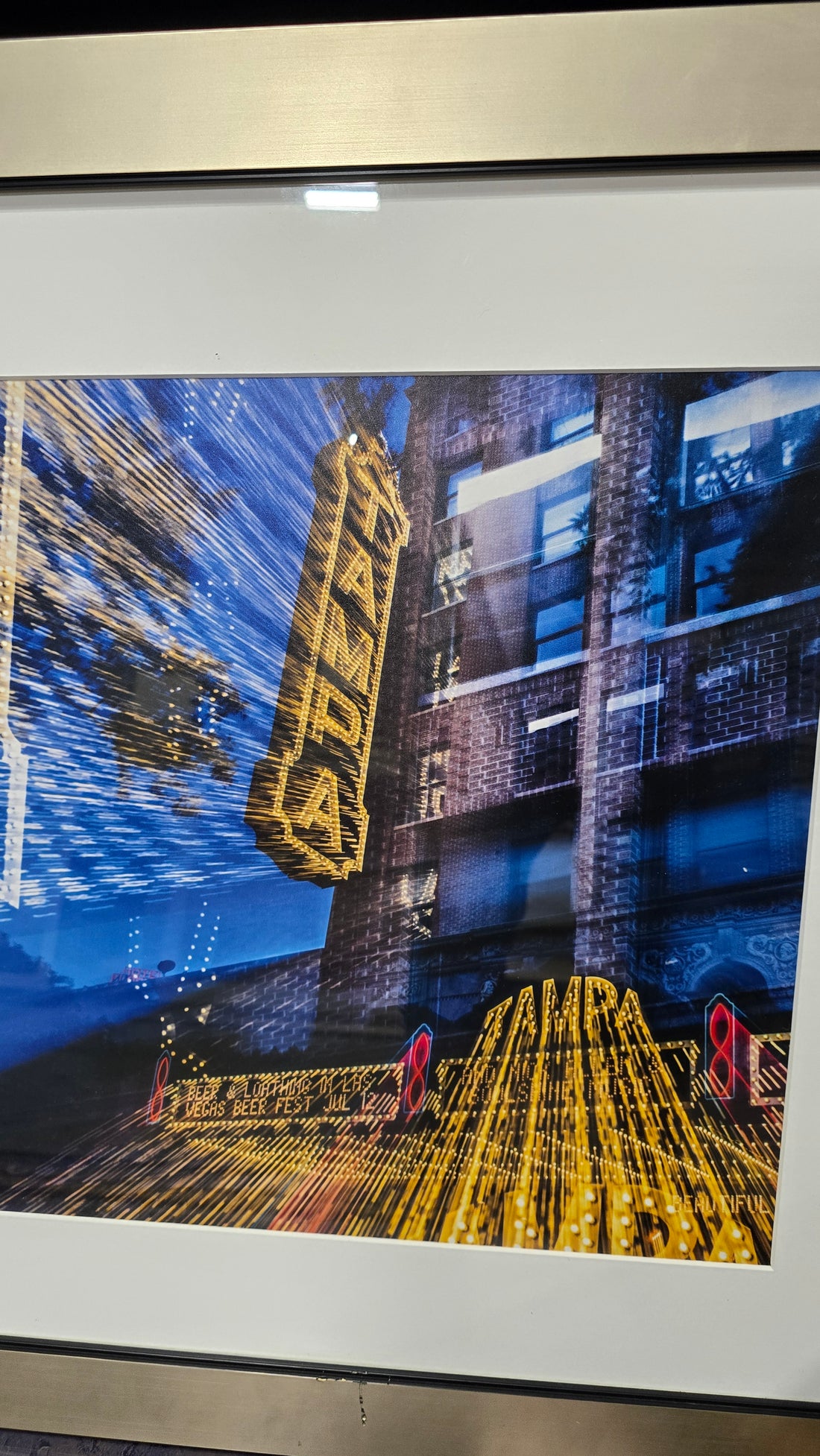 Angled view of Tampa city artwork, 25.5&quot; x 26&quot;, with sleek silver frame and urban design detail.