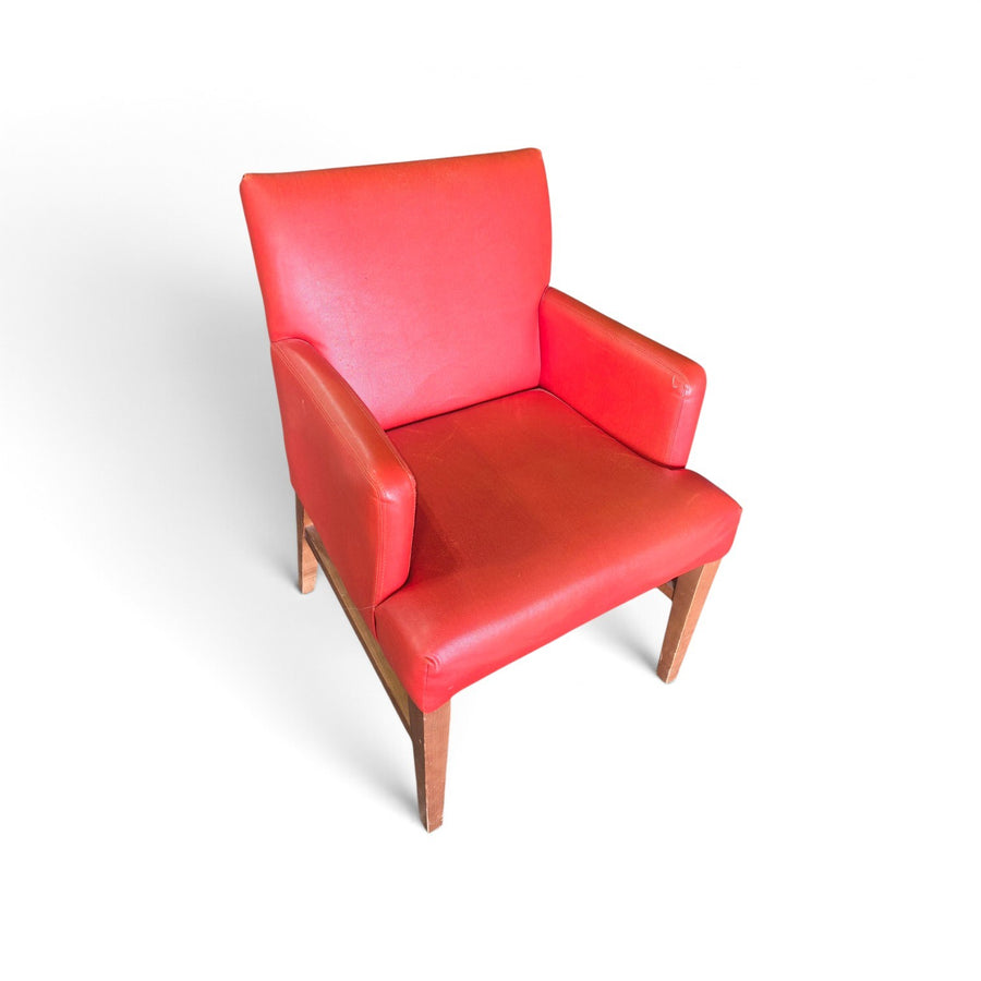 Alt Text: Used red vinyl upholstered dining chair with padded arms and brown wood-finish legs, SHL