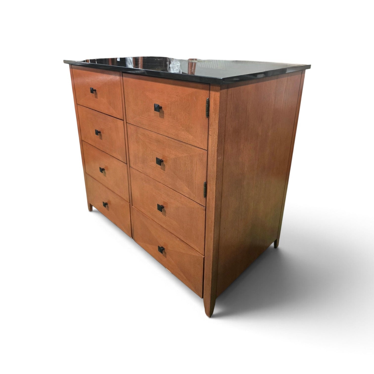 Angled view of a used 6 drawer dresser with black granite top and wood finish from Southern Hospitality Liquidation