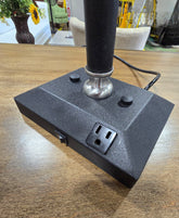 Close-up of the base on a used desk lamp featuring an integrated power outlet and power switch available at Southern Hospitality Liquidation.