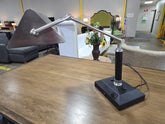 Side view of a used adjustable brushed nickel desk lamp with geometric metal shade sourced from an upscale resort.
