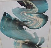 Close-up of blue, teal, black, and white abstract brushstroke artwork in a silver frame sourced from an upscale resort.