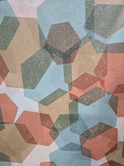 Close-up detail of used geometric abstract framed wall art with overlapping polygon shapes in coral, blue, olive, and tan from Southern Hospitality Liquidation.
