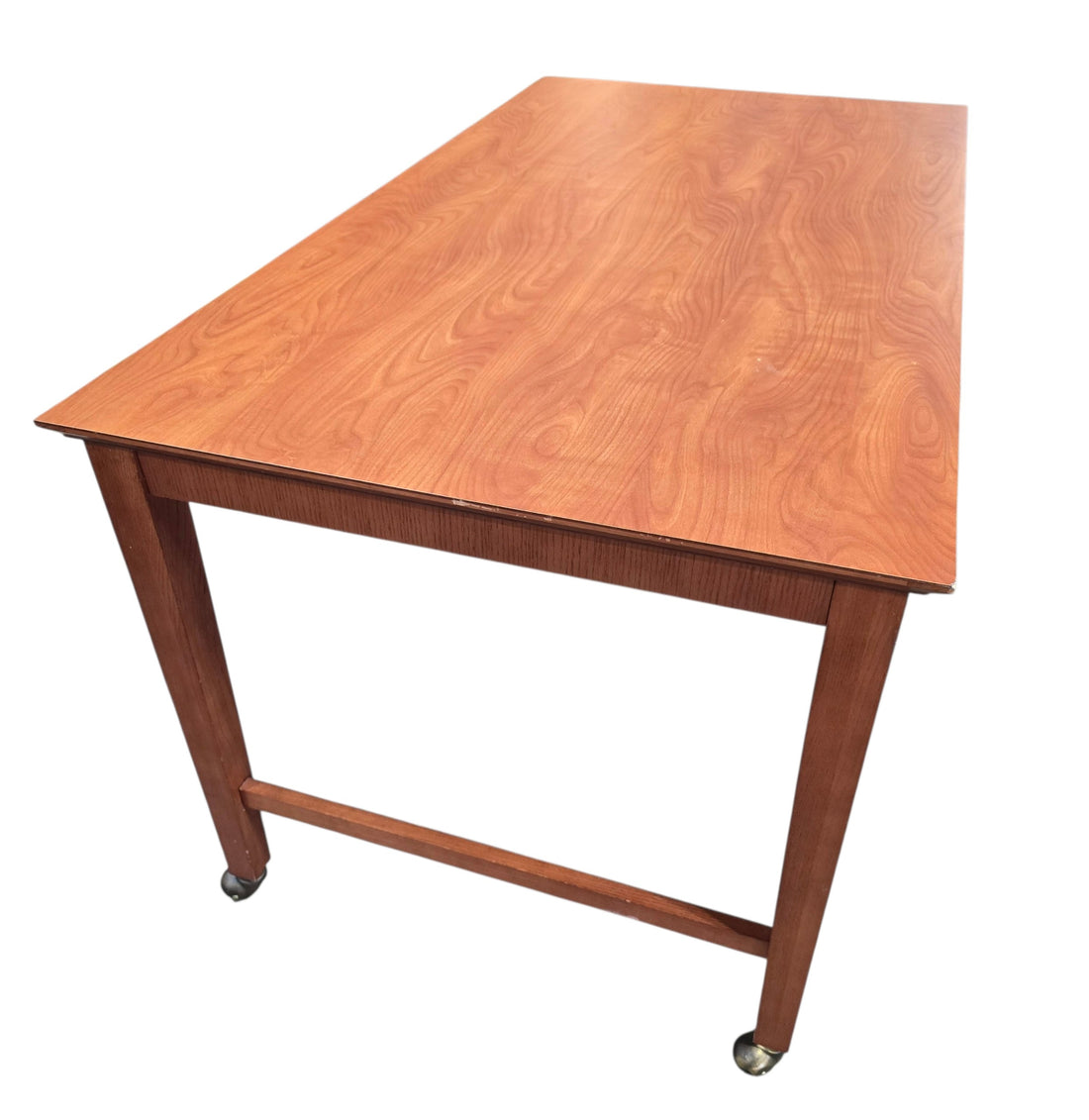 Used rolling wood writing desk with spacious work surface and brass casters, angled view, at Southern Hospitality Liquidation in Cartersville, GA.