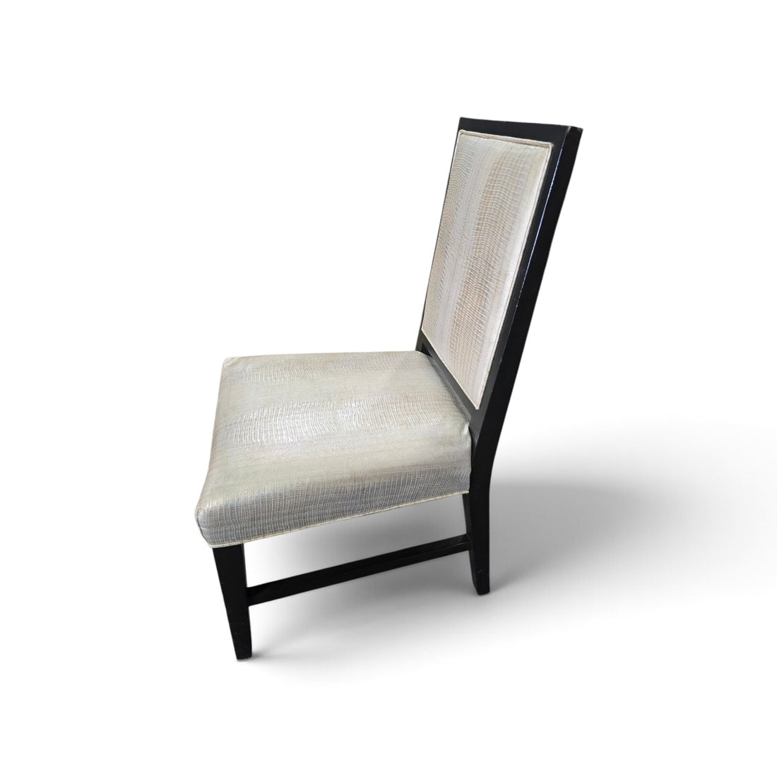 Side view of a used dining chair with shiny embossed vinyl upholstery and black wood frame from Southern Hospitality Liquidation.