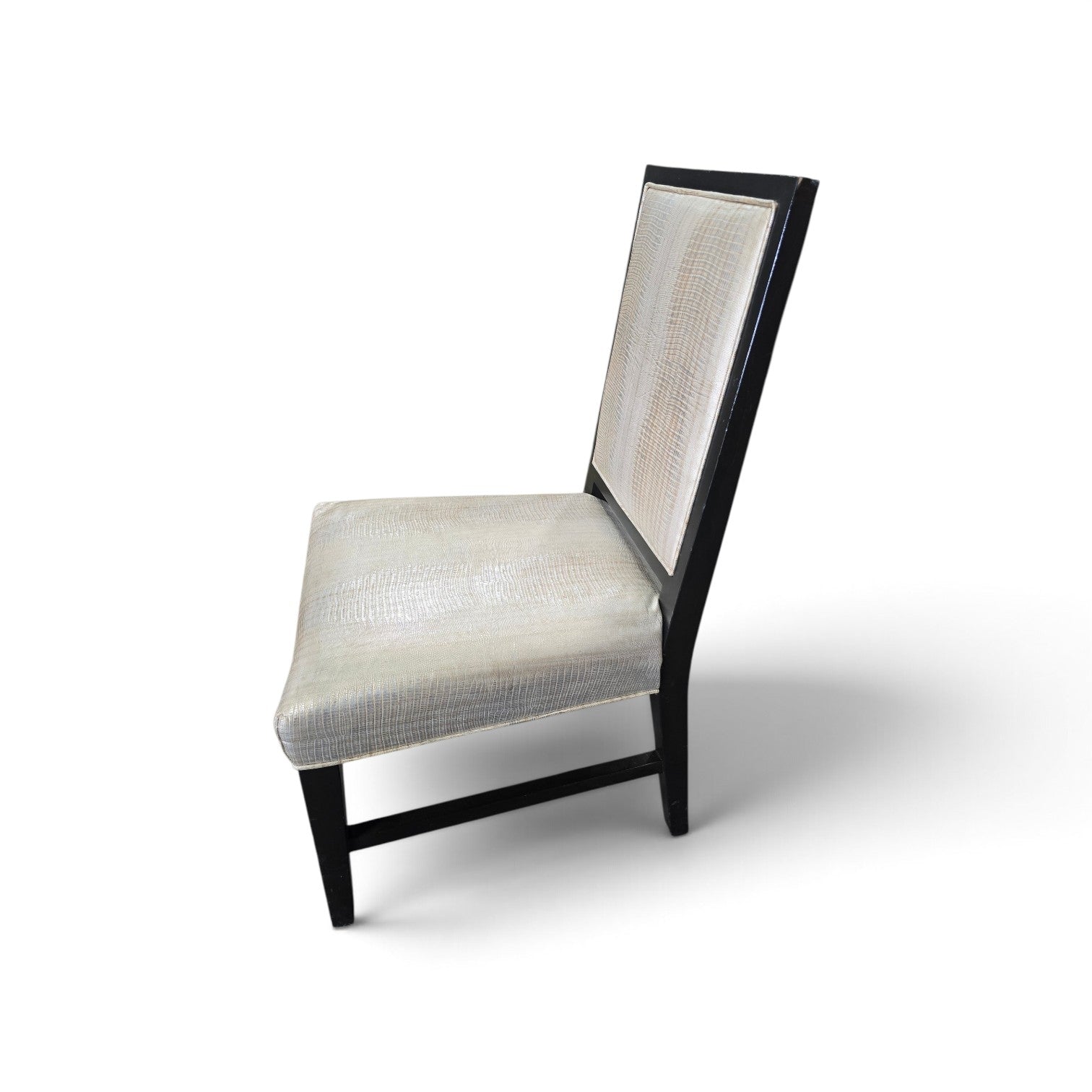 Side view of a used dining chair with shiny embossed vinyl upholstery and black wood frame from Southern Hospitality Liquidation.