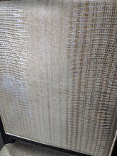 Close-up of the shiny embossed vinyl upholstery on a used dining chair from Southern Hospitality Liquidation.