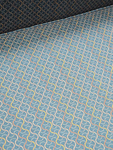 Close-up of the teal green geometric patterned upholstery on a used queen sleeper sofa from Southern Hospitality Liquidation.