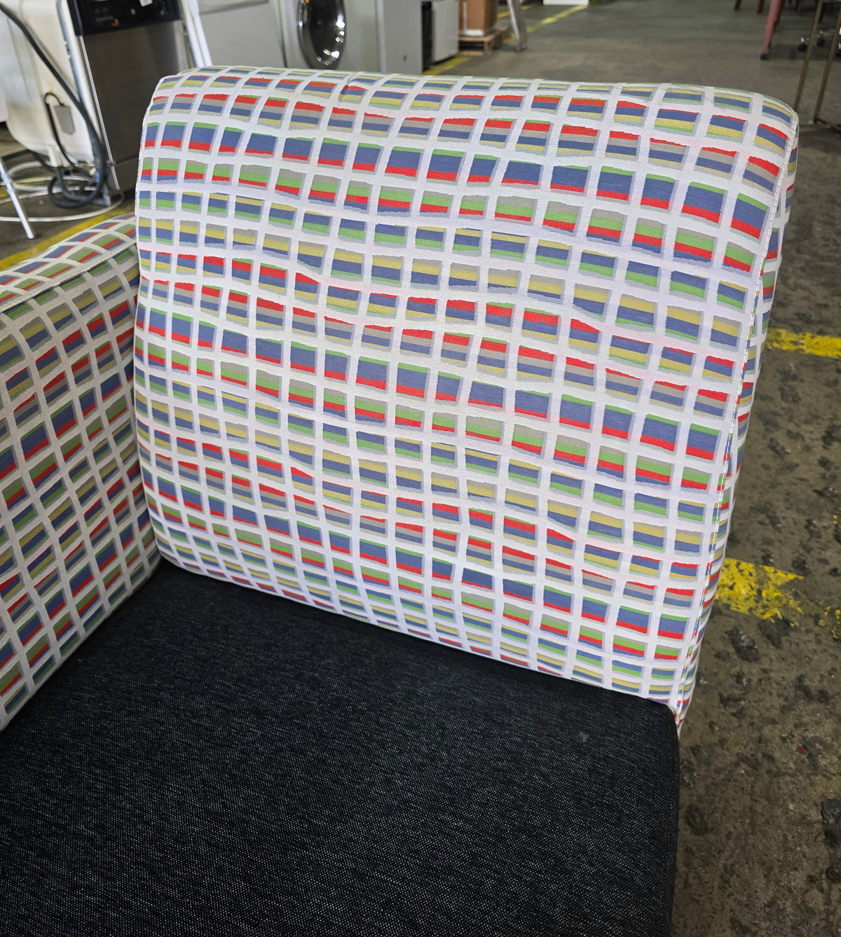 Close up of chaise lounge with charcoal gray seat, colorful geometric patterned back , SHL
