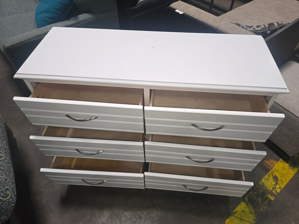 Open drawers showing storage space in a used white 6-drawer dresser, SHL.