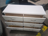 Open drawers showing storage space in a used white 6-drawer dresser, SHL.